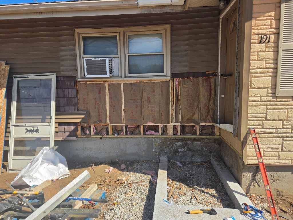 Before — sheathing and insulation exposed under a window during siding repair in Sutton, MA Before — sheathing and insulation exposed under a window during siding repair in Sutton, MA